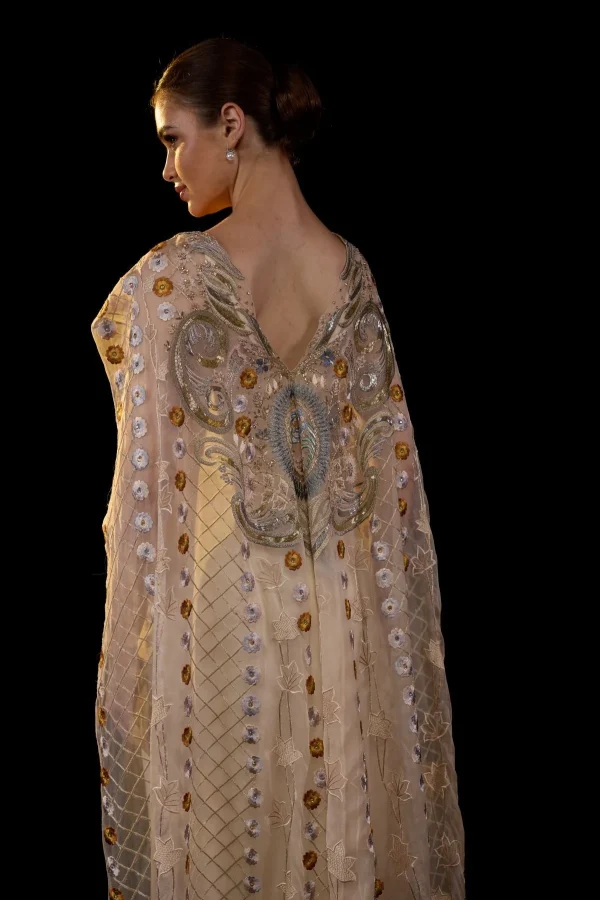 A SHEER NECK, FLOOR-LENGHT EMBROIDERED GOWN CAPE DRAPES FROM THE SHOULDERS - Image 3