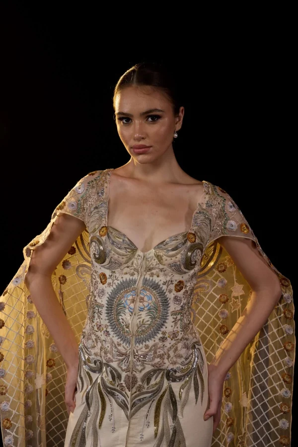 A SHEER NECK, FLOOR-LENGHT EMBROIDERED GOWN CAPE DRAPES FROM THE SHOULDERS - Image 2